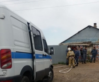 Казак президентинин сүрөтү чапталган эски үйдүн эшигин полиция талкалап, бузуп кирди