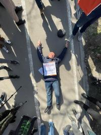 Жарандык активист Токтонасыров "Жаша Украина" деген жазууну төшүнө коюп, жерге жатып акция өткөрдү